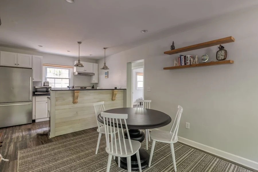 Kitchen and dining area with an island, table and shelves
