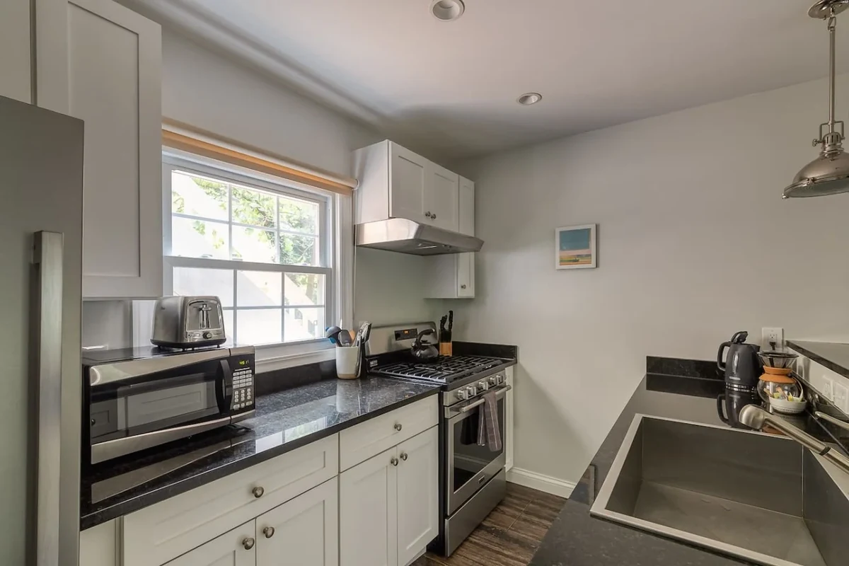 Ann Arbor home kitchen with white cabinets, range and black counters